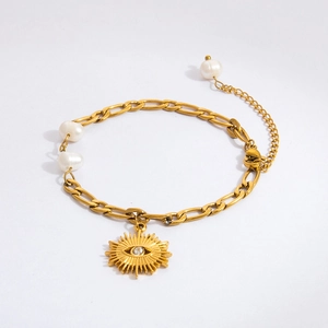 Detail of 18K gold evil eye charm bracelet with starfish and white freshwater pearls