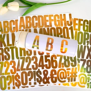 Macro view of 2-inch golden holographic alphabet and number stickers for DIY party decor
