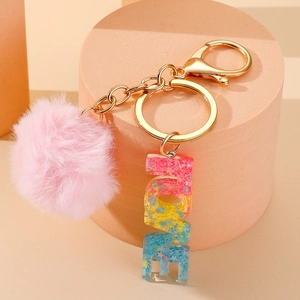 Detail of LOVE letter keychain with colorful sequins resin and pink faux fur pom pom charm