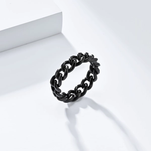 Macro detail of glossy black titanium steel Cuban link ring on a minimalist white stand