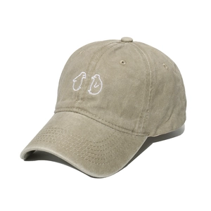 Detailed close-up of khaki washed cotton baseball cap with cute penguin embroidery