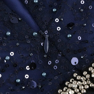 Gros plan sur la broderie à paillettes et la fermeture éclair invisible de la robe