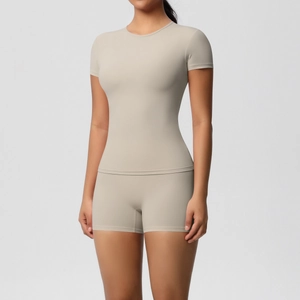 Front view of a beige two-piece athletic set featuring a short sleeve t-shirt and biker shorts