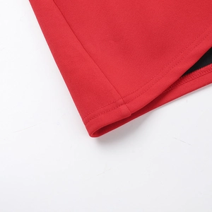 Dettaglio ravvicinato delle cuciture precise e del tessuto rosso di un abito a trapezio