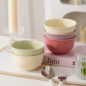 Minimalist ceramic bowls in pastel colors set on a cozy dining table scene