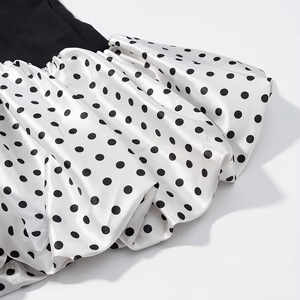 Detailed macro view of the black and white polka dot satin fabric with ruffled pleats