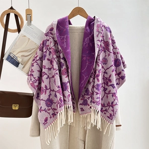 Close-up of purple floral jacquard shawl with fringe on beige coat for autumn winter
