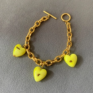 Detail of gold chain bracelet with yellow heart glass charms and OT toggle clasp