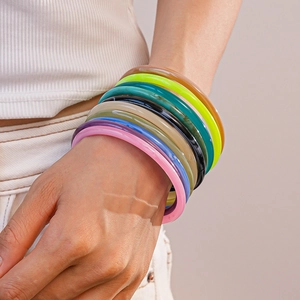 Close-up of stacked colorful acrylic resin bangles with a translucent marble texture