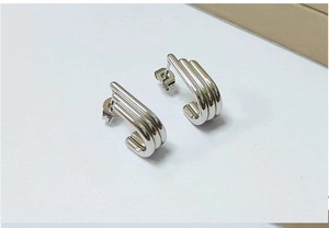 Macro shot of silver triple-row cylindrical tube hoop earrings with polished finish