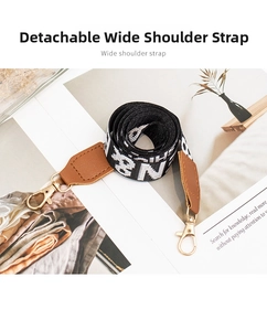 Detail of detachable wide woven jacquard shoulder strap with brown leather and gold hooks