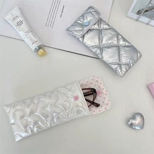 Detail of quilted PU eyewear pouches with heart stitching and heart-shaped snap buttons