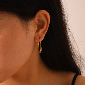 Close-up of minimalist U-shaped gold earrings worn for an elegant daily look