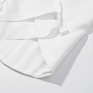 Gros plan sur la texture du tissu blanc avec un nœud en ruban délicat et élégant