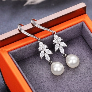 Luxurious long drop pearl earrings with teardrop pearls and rhinestones on orange box