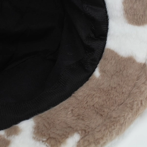 Macro shot of faux fur cow print bucket hat with soft fabric lining for winter warmth