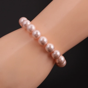 Detail of soft pink pearl bracelet with smooth round beads on a model wrist