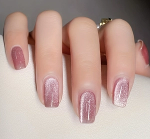 Macro shot of dusty rose cat-eye press-on nails with shimmering magnetic metallic effect
