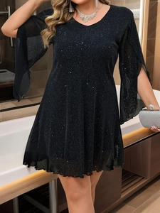 Dettaglio del vestito nero con paillettes, scollo a V e eleganti maniche a spacco