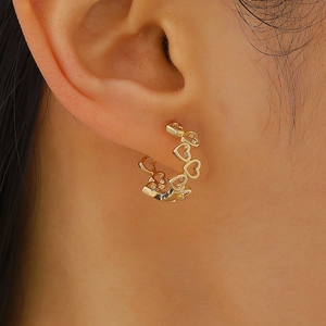 Detailsicht goldener Ohrringe mit hohlem Herz-Design und kreisförmigem Creolen-Stil