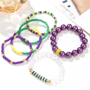 Bohemian beaded bracelet set with purple pearls and rainbow clay beads on a white desk