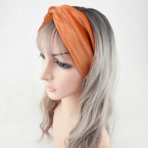Orange velvet twist headband for women shown on model from a side view angle