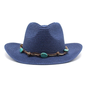 Détail d'un chapeau de soleil bleu marine en paille avec perles turquoise et cordon tressé