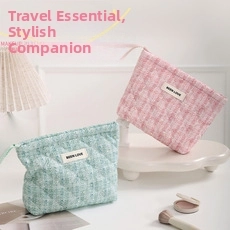 Detail of pink and mint green tweed makeup bags with rhombic stitching and top handle