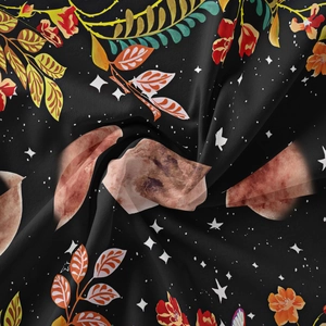 Close-up of floral moon phase pattern on soft black bohemian tapestry fabric