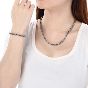 Ensemble collier et bracelet en chaîne byzantine argentée porté par un mannequin