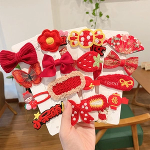 Detail view of red floral hair clip set with embroidery and cute strawberry charms