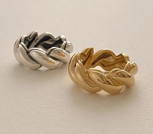Close-up of gold and silver chunky twisted rope rings with a polished metal texture
