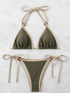 Flat lay of olive green string bikini with tortoise rings and cream trim detail