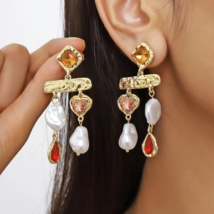 Detail of vintage long earrings featuring baroque pearls and colorful rhinestones