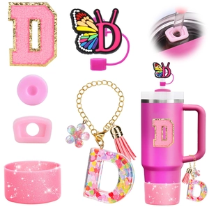 Pink accessory set for tumbler featuring butterfly straw cover and glitter silicone boot