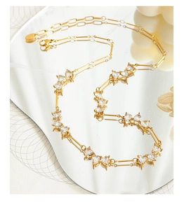 Detail of gold-plated necklace featuring heart-shaped zircon settings and a lobster clasp
