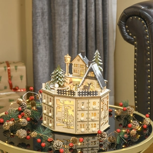 Close-up of wooden Christmas advent calendar featuring LED lights and miniature snow scene