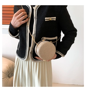 Macro view of champagne gold sequined spherical evening bag with metal chain strap