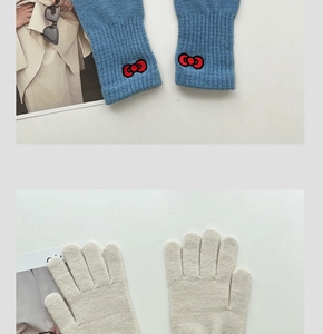 Detail view of blue knit fingerless gloves with red bows and white full-finger mittens