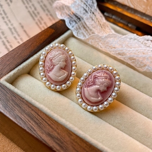 Vintage relief earrings with pink portrait, gold trim and pearls in a wooden jewelry box