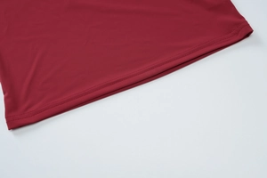 Gros plan détaillé de l'ourlet du haut rouge avec couture professionnelle à double aiguille