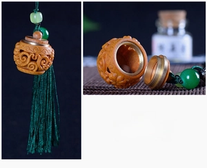 Detailed carved sandalwood sachet pendant with green silk tassel and emerald beads