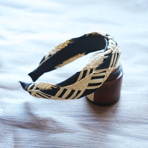 Macro detail of beige woven raffia texture and black fabric lining on wide headband