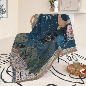 Detailed view of woven Bohemian blanket texture with moon, snake, and fringe tassels