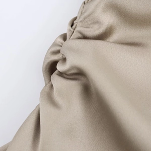 Gros plan sur le tissu en satin doré champagne avec des détails de plis élégants