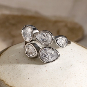 Macro view of five pear-cut clear zircons set on a polished silver stainless steel ring