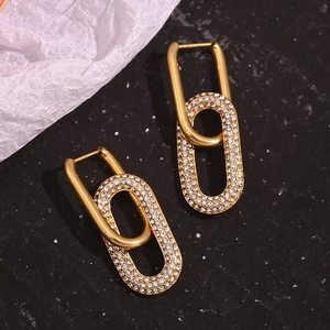 Close-up of gold-plated hoop earrings with micro-pave cubic zirconia on black texture