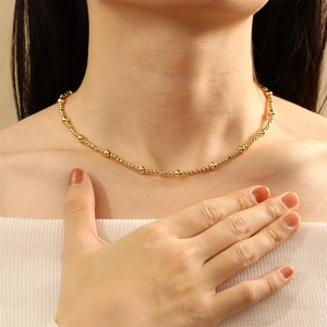 Close-up of elegant gold beaded necklace worn on neck with high polished finish