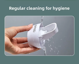 Waterproof white automatic toothpaste dispenser being washed under running water
