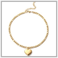 Detail of 18K gold Figaro chain featuring a polished heart pendant and adjustable link